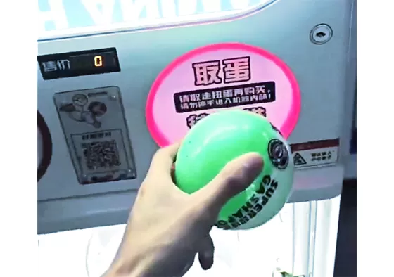 Step 3: The capsule toy drops into the collection tray.