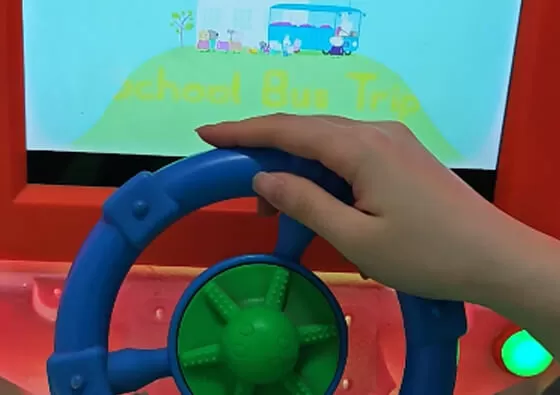 2. Mount Comfortably: Children sit securely on the pig-shaped seat, holding onto the side grips for stability during the ride.