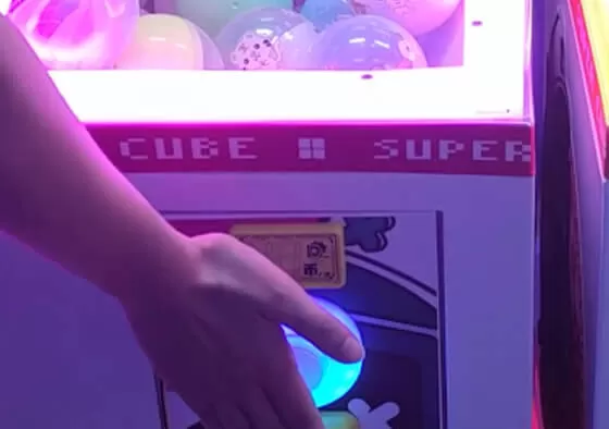 2. Press the Operation Button: Press the button to release the gashapon capsule from the track.