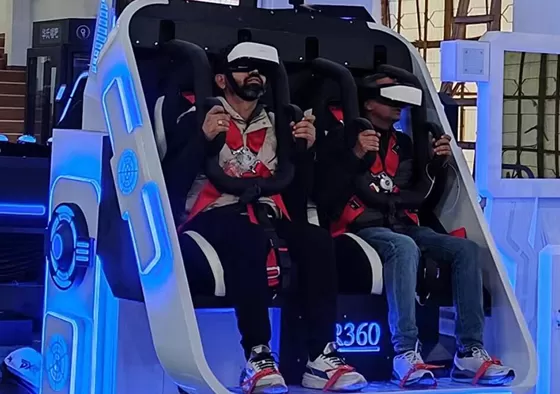 2. Players wear VR glasses and adjust seat straps.
